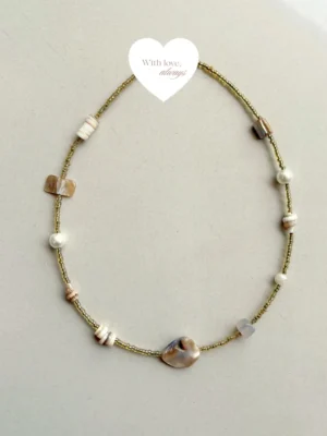 Delicate beach-inspired necklace featuring golden beads