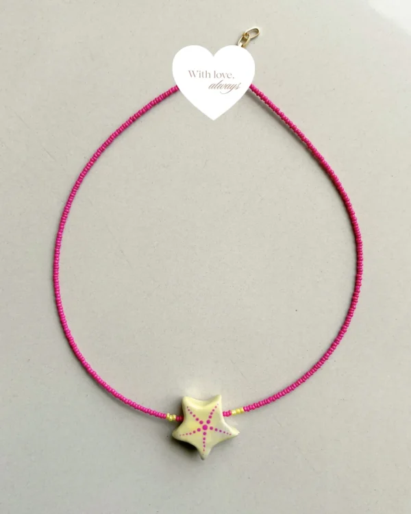 Necklace featuring vibrant pink seed